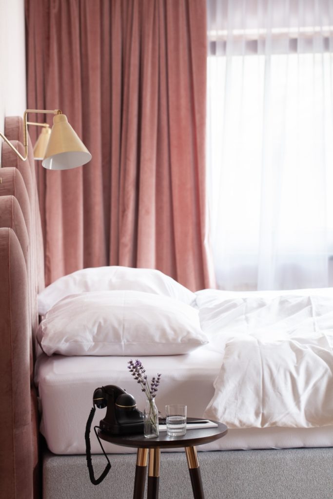 Hotelzimmer mit Retrotelefon und Rosé Samtstoffen